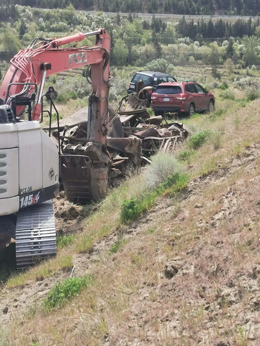 Excavator working through debris on the hillside