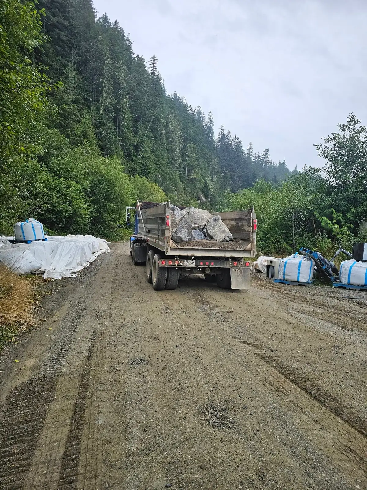 Dump truck hauling rock up the gravel access road