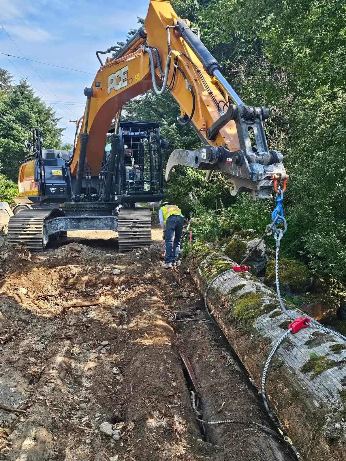 PCE excavator clearing along the edge of the right-of-way