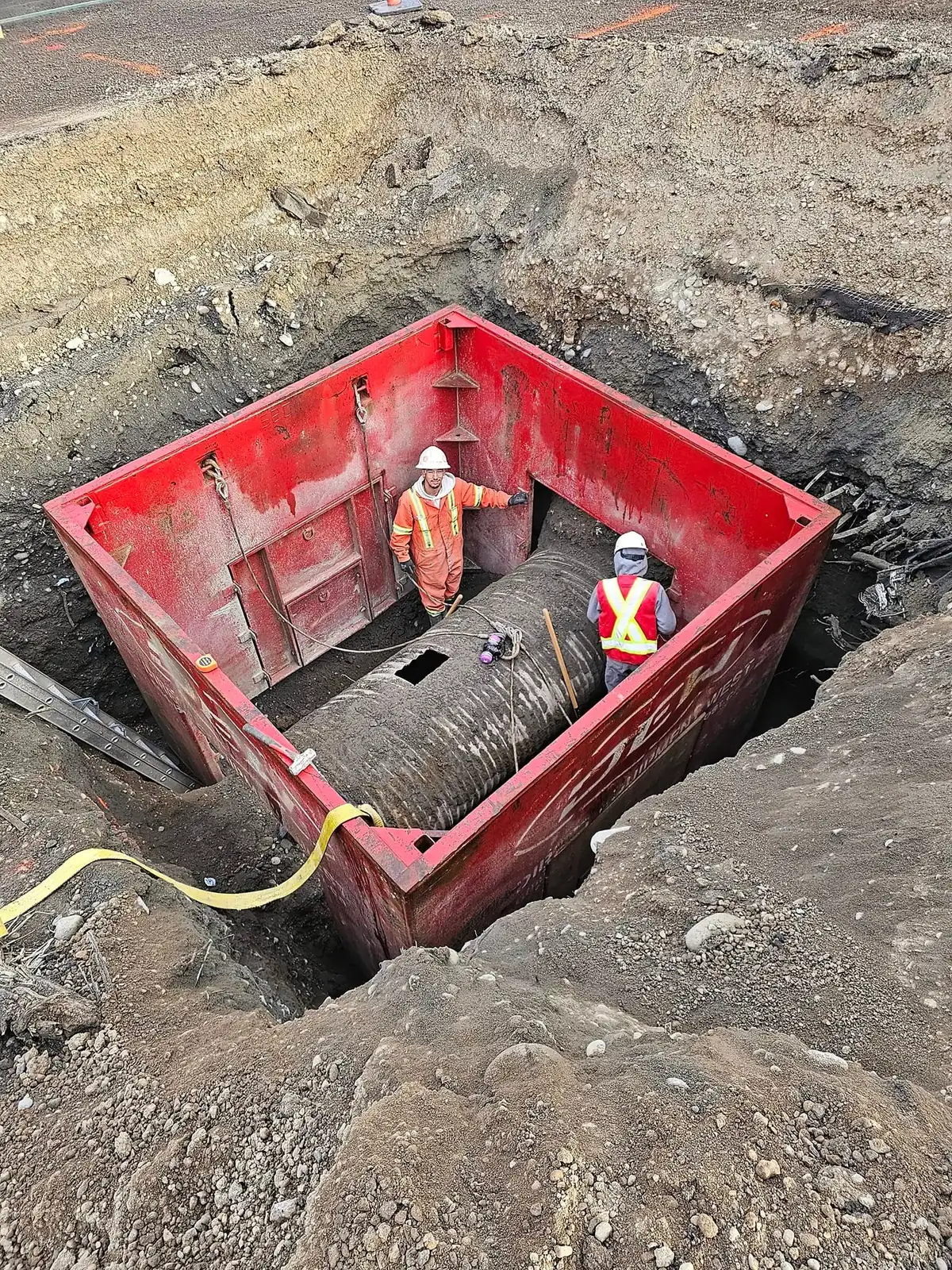 Crew inside a deep shoring box at the pipe connection