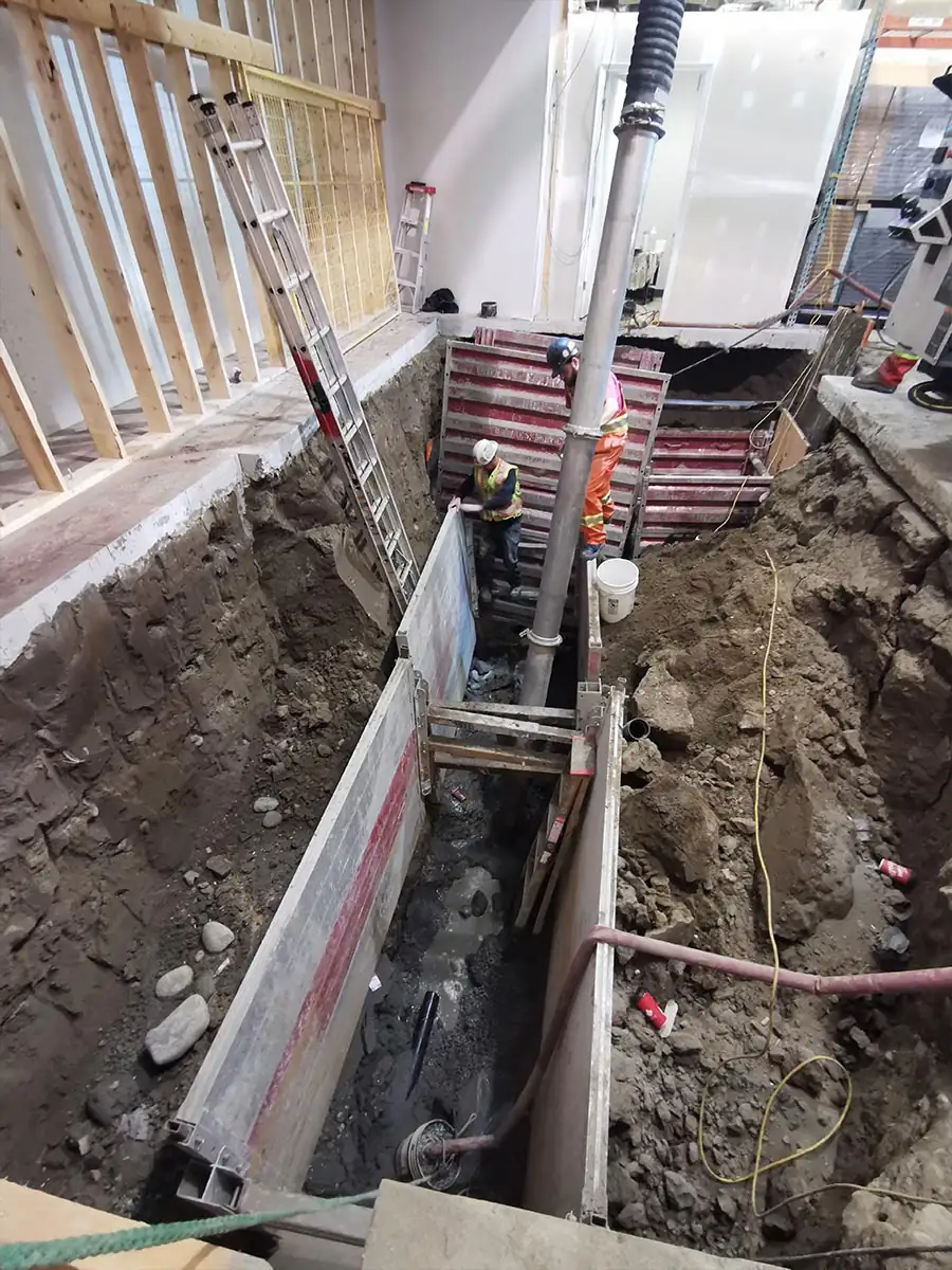 Shored trench running between units inside the building